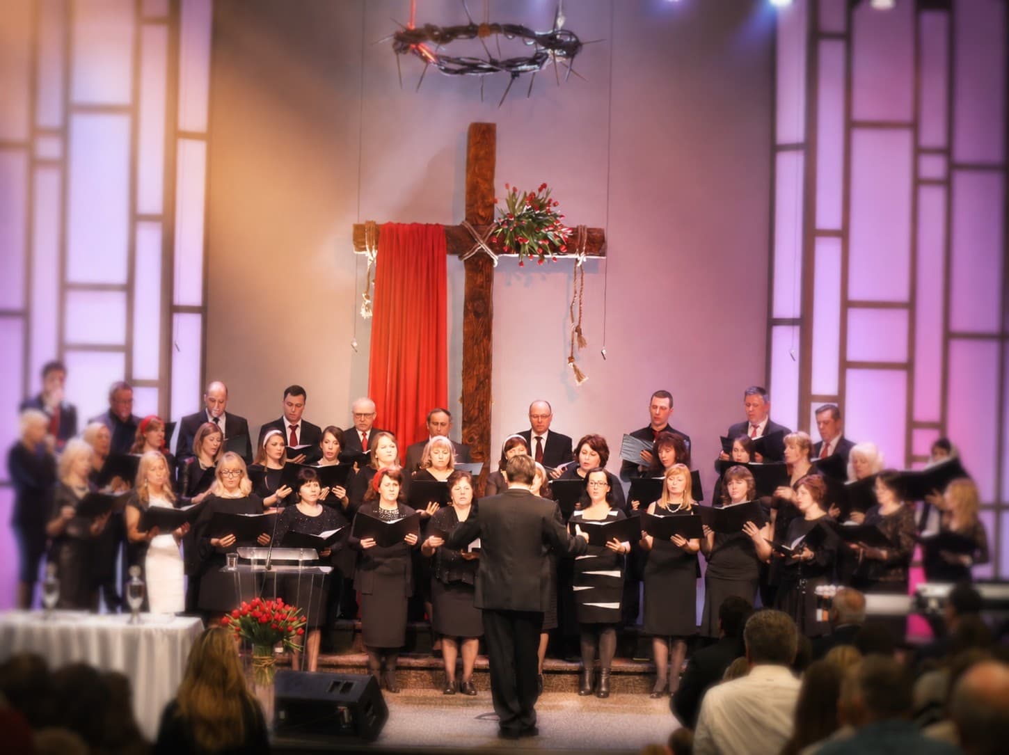 Revival Church choir singing on stage beneath the cross